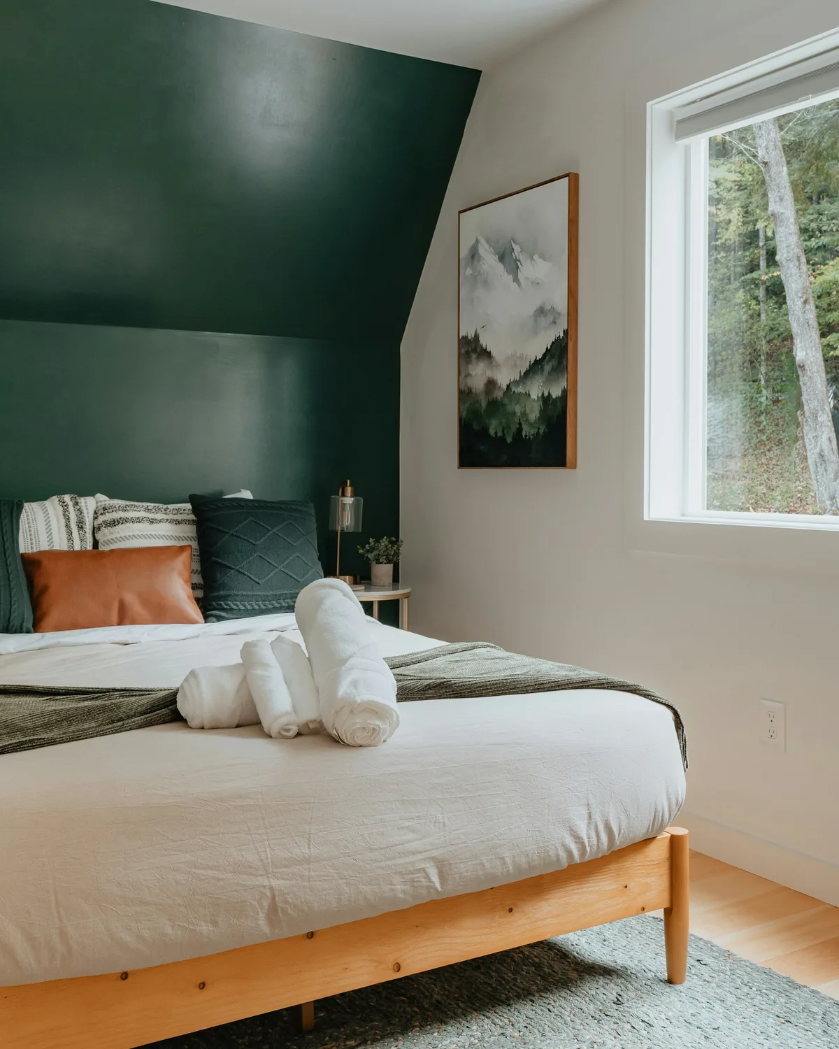 A made bed with white bedding, pillows and a wooden bed frame